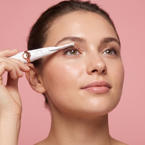 Woman applying the LashSet heated eyelash curler at the lash root — editorial beauty shot on pink background