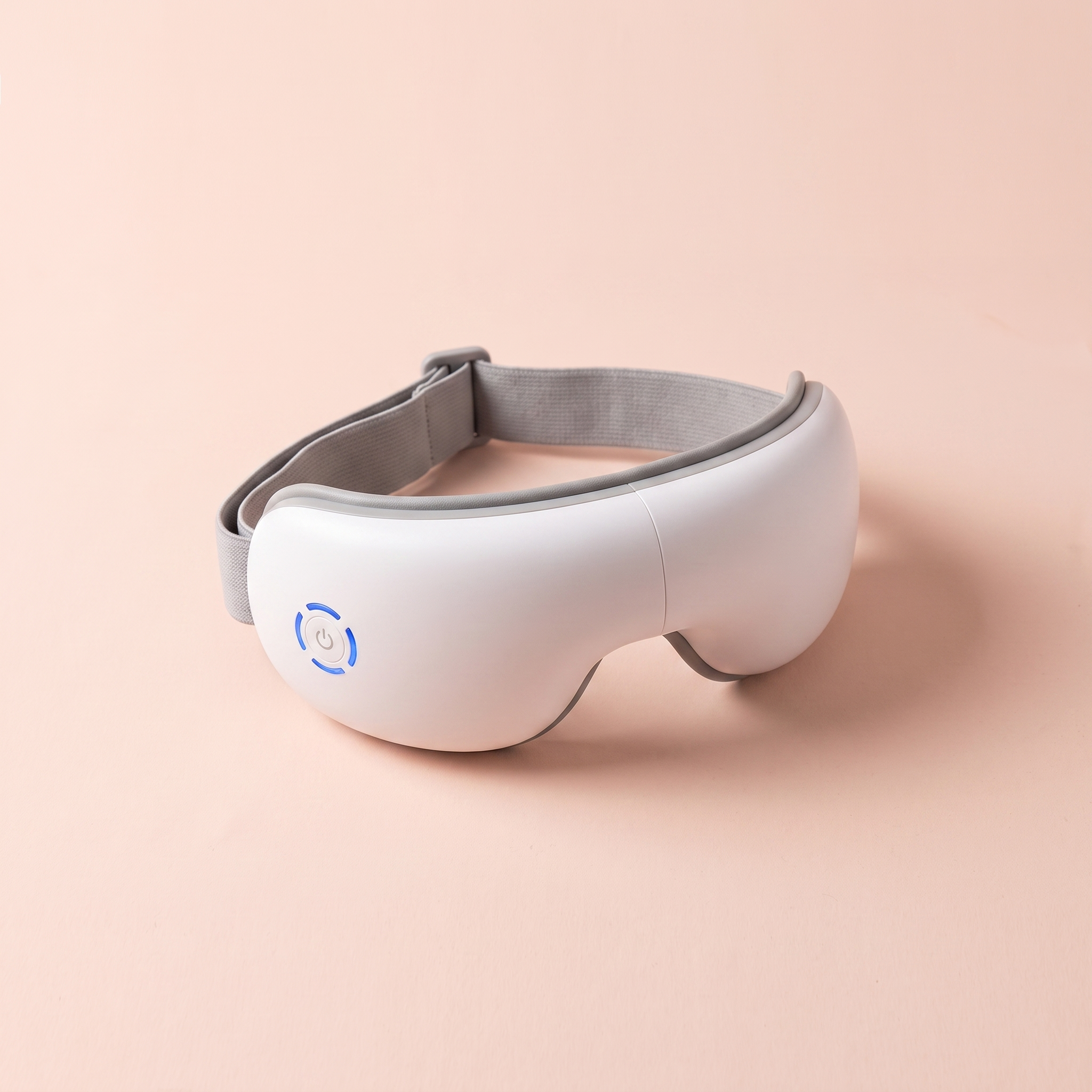 Heated Eye Massager (Air-Compression + Bluetooth) — peach editorial product photo