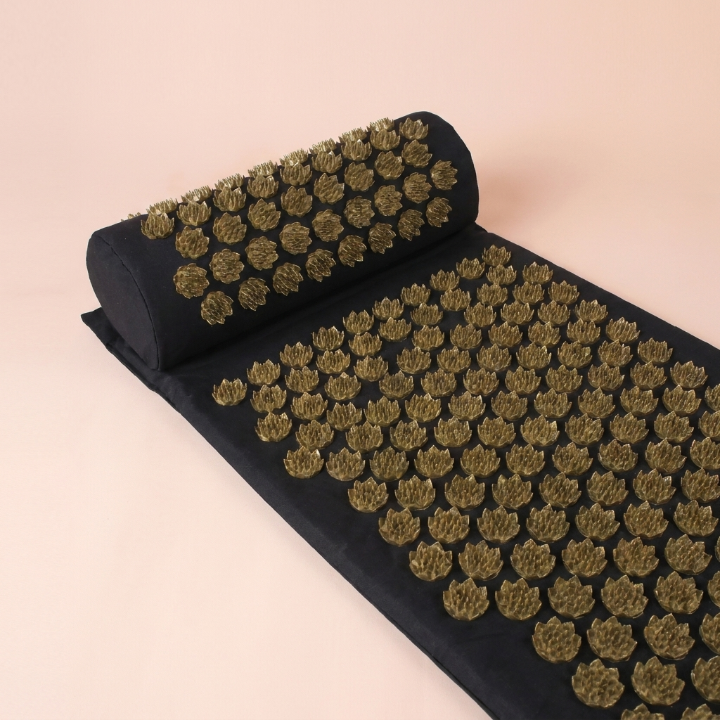 Acupressure mat and neck pillow arranged together, three-quarter view on peach studio background