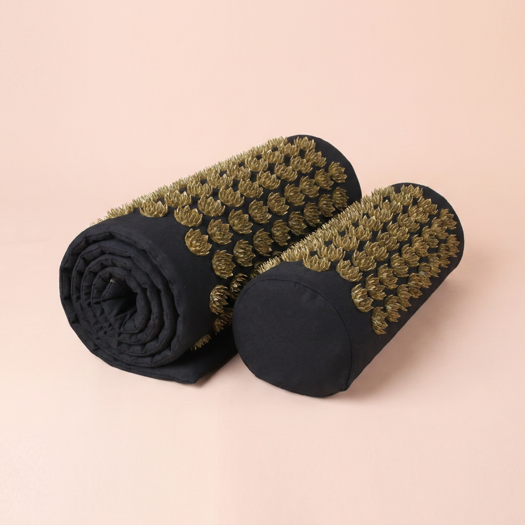 Acupressure mat rolled up with the neck pillow beside it on peach studio background