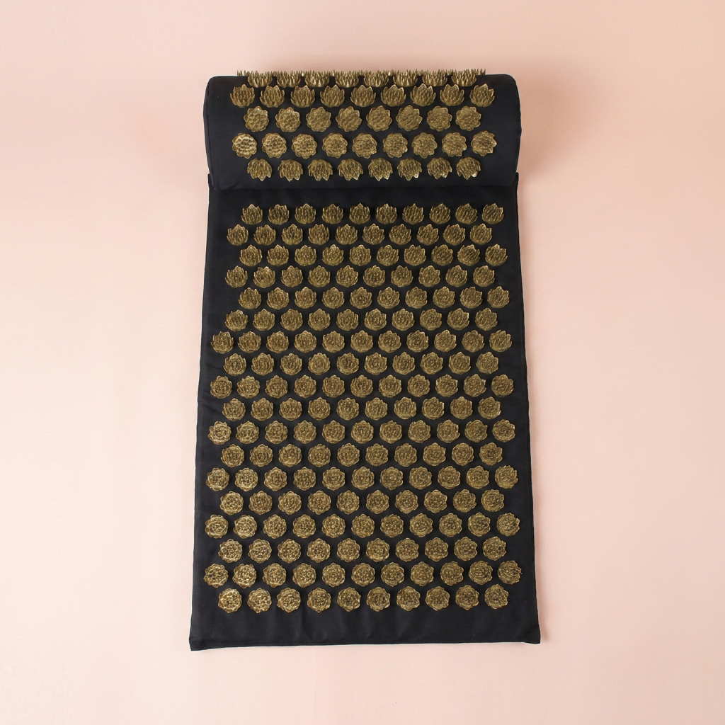 Acupressure mat laid flat, top-down view on peach studio background