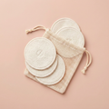 Reusable cotton rounds and wash bag on blush background