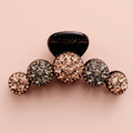 Rhinestone claw hair clip on blush background
